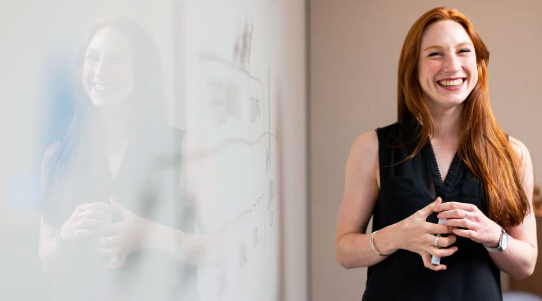 woman smiling standing in front of white board