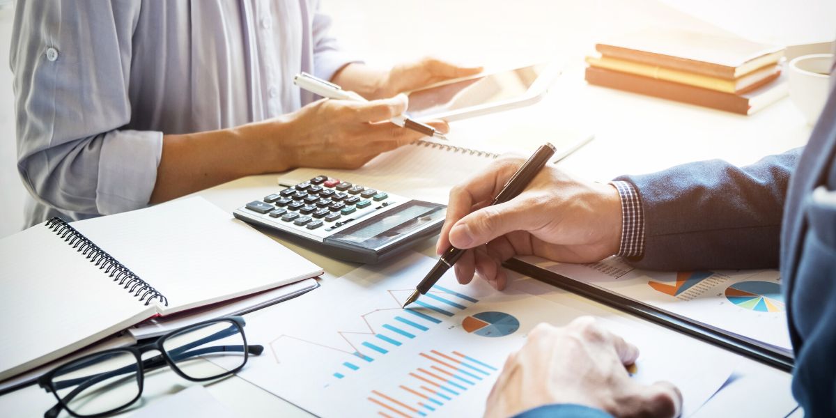 two people working on data and charts