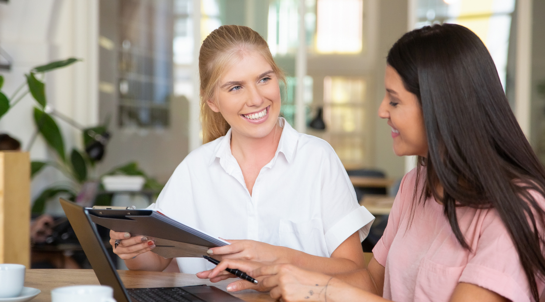 Woman at table explaining the difference between a Non-ERISA vs ERISA Retirement Plan to another woman.